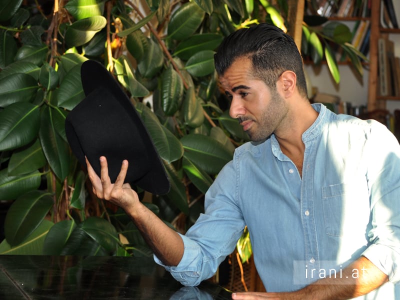 مردی با کلاه در کنار پیانو در نمایشگاه عکس ایرانی.